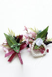 Burgunderfarbene Ball-Corsage am Handgelenk und Herren-Boutonniere mit Perlen