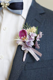 Burgunderfarbene Ball-Corsage am Handgelenk und Herren-Boutonniere mit Perlen