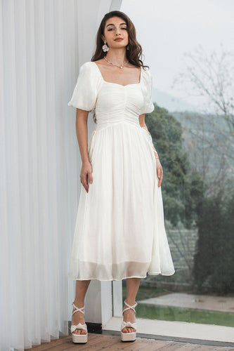 Ein gefaltetes plissiertes weißes Kleid mit Puffärmeln