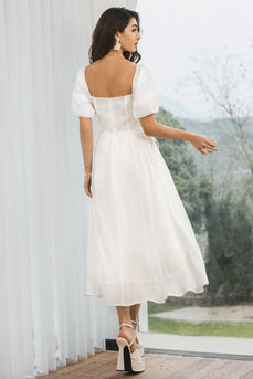 Ein gefaltetes plissiertes weißes Kleid mit Puffärmeln