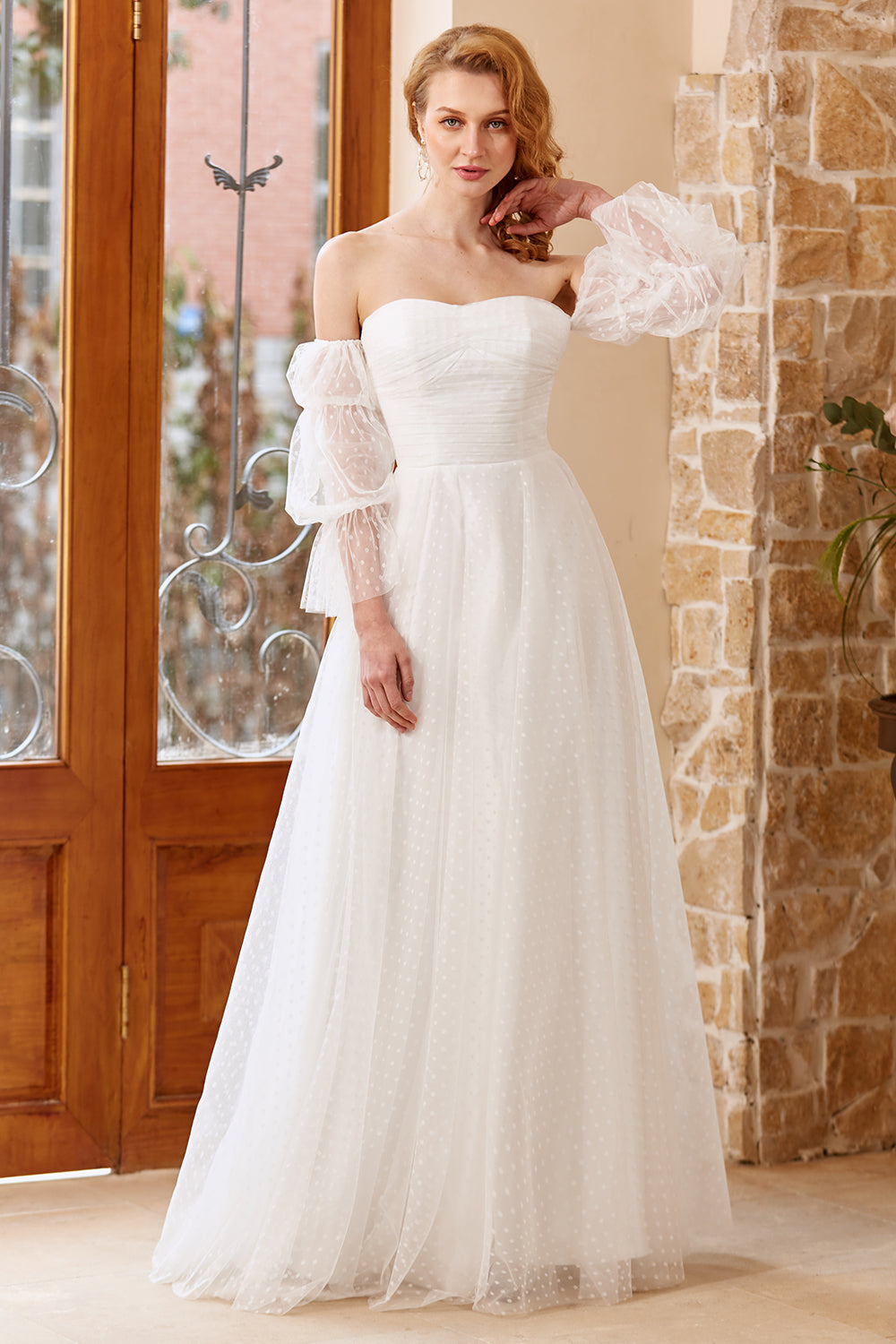 Ein schulterfreies weißes Brautkleid mit langen Ärmeln